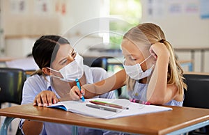 Education, covid and learning with face mask on girl doing school work in classroom, teacher helping student while