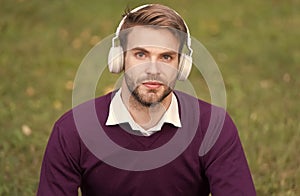 education with ebook. man with bristle in headset listening music while relax in park. guy learning with audio book. get