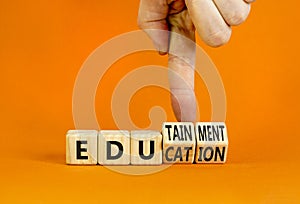 Education and edutainment symbol. Concept words Education and edutainment on wooden cubes. Teacher hand. Beautiful orange table