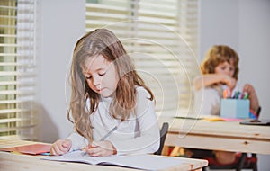 Education, elementary school, learning and people concept, group of school kids with pens and notebooks writing.