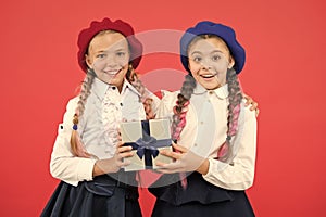 Education is the gift that continues to give. Happy little girls holding gift box on pink background. Small children