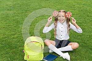 Education gives sweet. funny child hold lollipop. concept of education. ordinary learning day. cute girl read book after