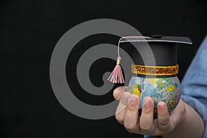 Education in Global world, Graduation cap on the girl`s hand holding Earth