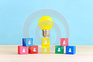 Education and human resource concept image. Creative idea and innovation. light bulb metaphor over blue background, wooden cubes