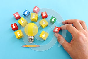 Education and human resource concept image. Creative idea and innovation. light bulb metaphor over blue background, wooden cubes
