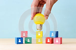 Education and human resource concept image. Creative idea and innovation. light bulb metaphor over blue background, wooden cubes