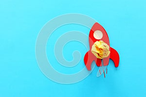 Education or innovation concept. Wooden rocket over blue background