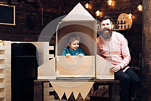 Education and kid idea development. Travel and adventure. Father and small boy in paper rocket. father day. Dream about
