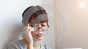 Education learning online study concept: Cute teenage Asian girl in gray t-shirt wearing glasses using and watching tablet for