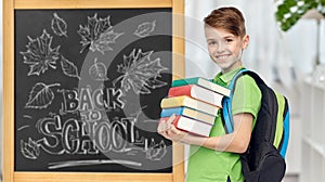 happy student boy with school bag and books