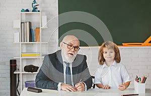 Education and learning. Teacher and pupil in school. Schoolboy in classroom.