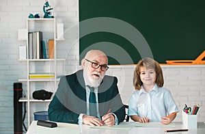 Education and learning. Teacher and pupil in school. Schoolboy in classroom.