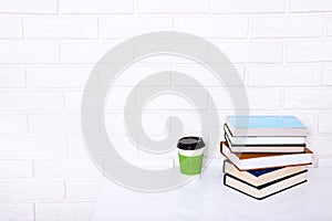 Education literature. Cup of coffee and books on the table in a class. Top view and copy space. Selective focus