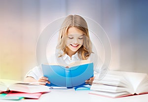 Happy smiling student girl reading book