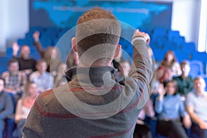 Education process at professor`s lecture in audience. Young male teacher giving presentation for students in a lecture hall