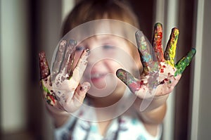 Education, school, art and painitng concept - little girl showing painted hands