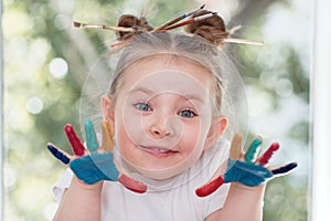 education, school, art and painitng concept - little student girl showing painted hands