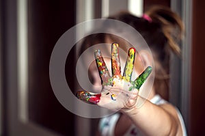 Education, school, art and painitng concept - little girl showing painted hands