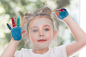 education, school, art and painitng concept - little student girl showing painted hands