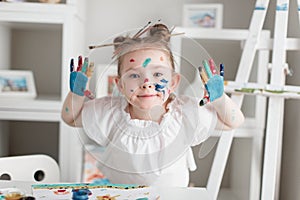 education, school, art and painitng concept - little student girl showing painted hands