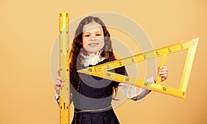 Education and school concept. Smart and clever concept. Sizing and measuring. Pupil cute girl with big ruler. School