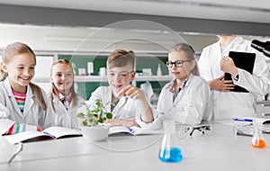 Kids or students with plant at biology class