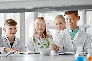 Kids or students with plant at biology class