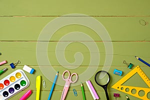 Education, studying and back to school concept. Bottom border frame made of stationery on wooden background with copy space for