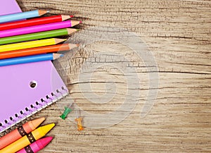 Education supplies on old wooden background. Colorful pencils