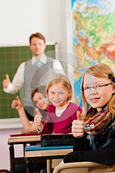 Education - Teacher with pupil in school teaching