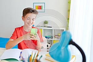Student boy with smartphone distracting from study photo