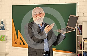Education trends. Online service. Videoconferencing keeps homebound students connected. Senior intelligent man teacher