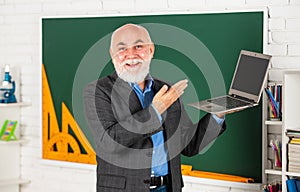 Education trends. Online service. Videoconferencing keeps homebound students connected. Senior intelligent man teacher photo