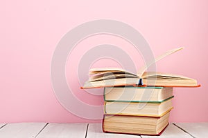 education and wisdom concept - open book on wooden table, color background