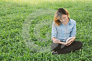 Education woman.Young beautiful woman reading a book in the park