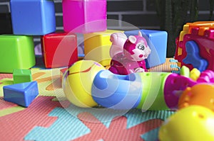 Educational children`s bright toys on the table. Puzzles, rattles, cubes and mechanical squirrel. Toys zero and older. Child`s