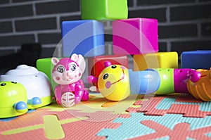 Educational children`s bright toys on the table. Puzzles, rattles, cubes and mechanical squirrel. Toys zero and older. Child`s