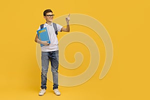 Educational Offer. Smiling Teen Schoolboy Holding Workbooks And Pointing Aside