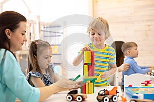 Educational toys for preschool and kindergarten children. Cute little kids playing with blocks in day care center.