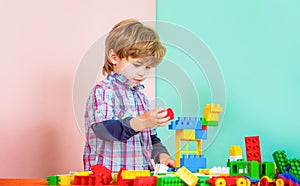 Educational toys for young children. Little boy playing with lots of colorful plastic blocks constructor. Boy playing