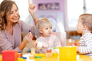 Educator and children having fun on learning in kindergarten. Teacher, education, kids and primary school concept . photo