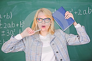 Educator woman hold book and pen chalkboard background. Looking for inspiration. Inspired work harder or pursue