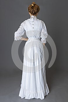 An Edwardian woman wearing a white lace blouse and skirt and a pearl necklace photo