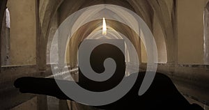 Eerie and Atmospheric Candle Flame Burning in a Dark and Mysterious Tomb Background