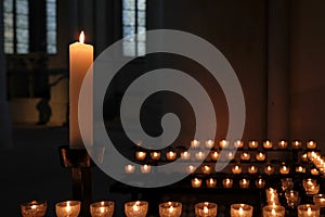 Eerie shot of candles on candle holders lighted on a dark room perfect for horror scenes