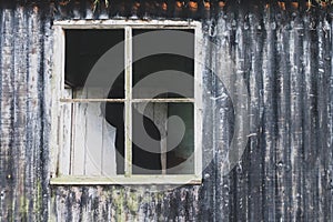 An eerie spooky hooded figures standing by a window in a ruined, abandoned house