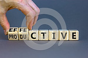 Effective and productive symbol. Businessman turns wooden cubes and changes the word `productive` to `effective`. Beautiful gr