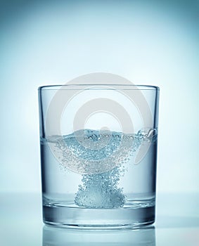 Effervescent dissolving fizzy tablet in water photo