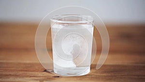 Effervescent pill dropping into glass of water