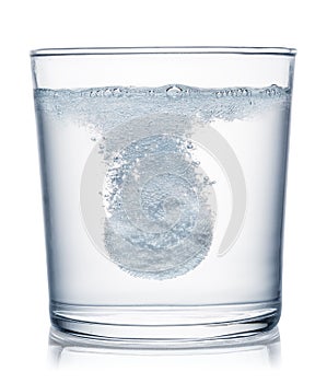 Effervescent tablet dissolving in a glass of water. Clipping path